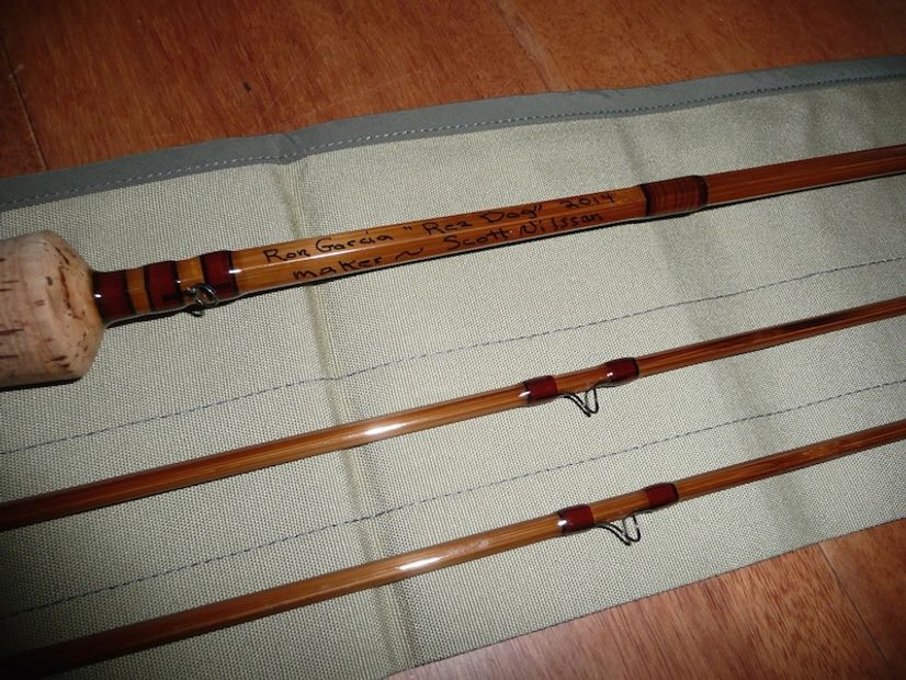 Bamboo fly rod and reel on wooden surface